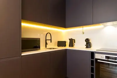 a kitchen with black and white cabinets and a microwave at Porto - Boavista Casa Da Música - Art Gallery Apartment I in Porto