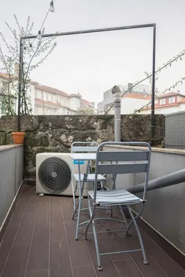 a table and a chair on a balcony with a stove at Liiiving in Porto - Downtown Comfort House in Porto