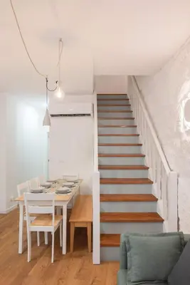 a staircase in a living room with a white table and chairs at Liiiving in Porto - Downtown Comfort House in Porto