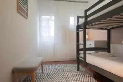 a bedroom with two bunk beds and a chair at Liiiving in Porto - Downtown Comfort House in Porto