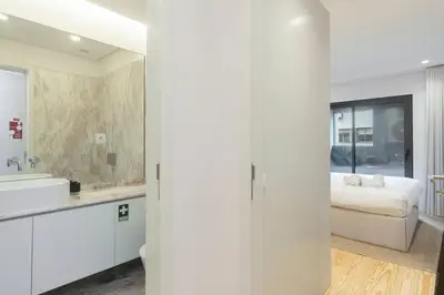 a white bathroom with a sink and a bed at Stylish Flat with Balcony, In Central Porto in Porto