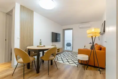 a living room with a table and chairs and a couch at Modern 1BR Apartment - Brand New Bonjardim F in Porto