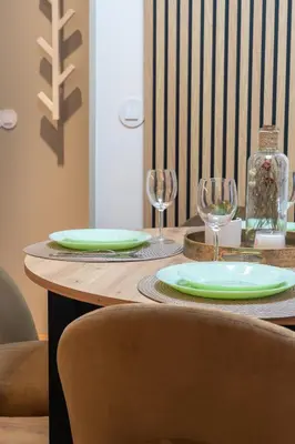 a table with two plates and wine glasses on it at Modern 1BR Apartment - Brand New Bonjardim F in Porto