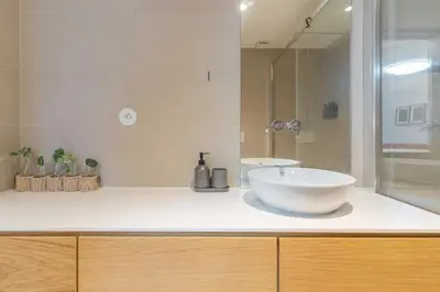 a white bathroom with a sink and a shower at Modern 1BR Apartment - Brand New Bonjardim F in Porto