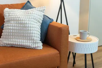 a pillow on a couch next to a side table at Modern 1BR Apartment - Brand New Bonjardim F in Porto