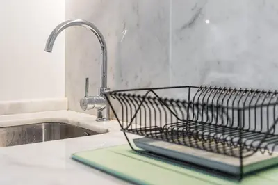 a metal dish rack sitting on a counter next to a sink at GuestReady - One Step Closer in Porto