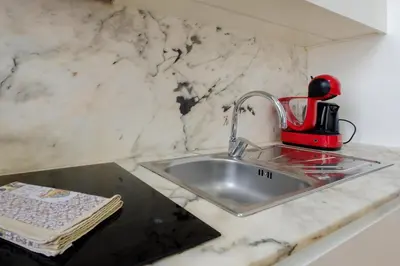a kitchen counter with a sink and a red appliance at Bright 2bedroom apartment in Bonfim, 2 minutes from Campanhã, Porto city center in Porto
