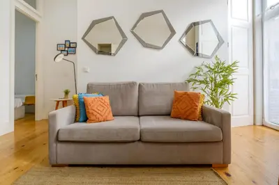 a couch in a living room with mirrors on the wall at Bright 2bedroom apartment in Bonfim, 2 minutes from Campanhã, Porto city center in Porto