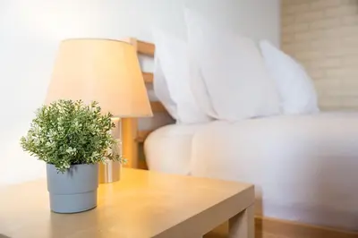 a lamp on a table next to a bed at GuestReady - Cosy Studio Near Arrábida Shopping in Vila Nova de Gaia