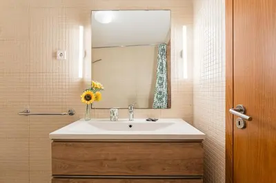 a bathroom with a sink and a mirror at GuestReady - Cosy Studio Near Arrábida Shopping in Vila Nova de Gaia
