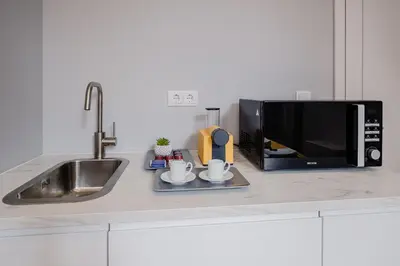 a kitchen counter with a sink and a microwave at Plaza - Charming GuestHouse in Porto