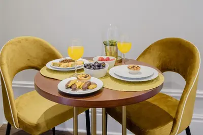 a table with plates of food and glasses of orange juice at Plaza - Charming GuestHouse in Porto