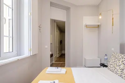 a white room with a bed and a window at Plaza - Charming GuestHouse in Porto
