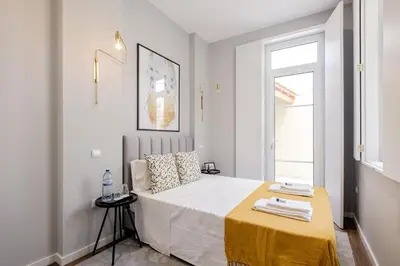 a bedroom with a bed with a yellow blanket on it at Plaza - Charming GuestHouse in Porto