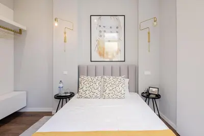 a bedroom with a large white bed with two side tables at Plaza - Charming GuestHouse in Porto