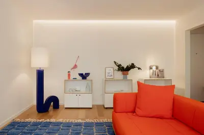 a living room with a red couch and a blue rug at Volta do Patio in Porto
