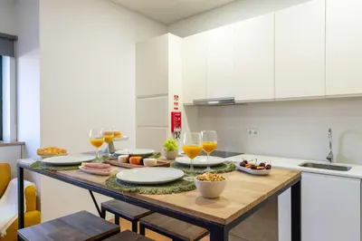 a kitchen with a table with food and wine glasses at Colorful & Cozy Apartment by HostWise in Porto
