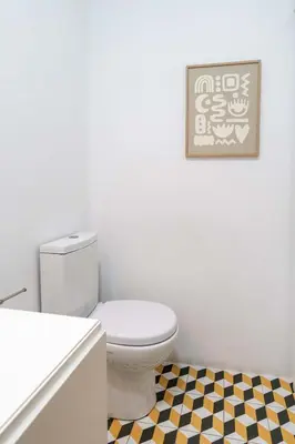 a bathroom with a toilet and a checkered floor at Colorful & Cozy Apartment by HostWise in Porto