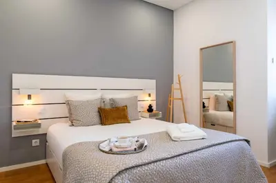 a bedroom with a large white bed with a mirror at Colorful & Cozy Apartment by HostWise in Porto