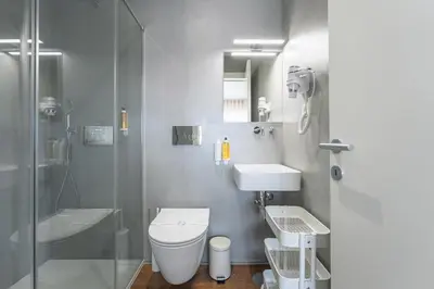 a white chair sitting on a balcony looking out at a street at Bom Sucesso Executive Flats by Feel Porto in Porto