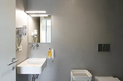a bathroom with a sink and a toilet and a mirror at Bom Sucesso Executive Flats by Feel Porto in Porto