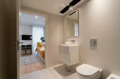 a bathroom with a toilet and a sink and a bedroom at Stylish Formosa Studio by HostWise in Porto