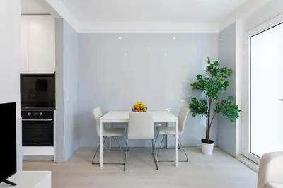 a white dining room with a white table and chairs at Authentic Retreat by HostWise in Porto