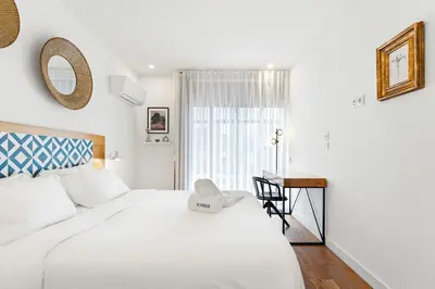 a bedroom with a large white bed and a desk at Historic Porto Flat, Central Porto in Porto