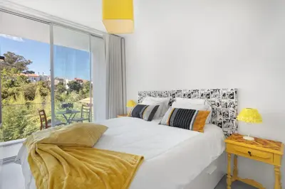 a bedroom with a white bed and a large window at Miguel Bombarda - Porto Houses & Suites in Porto