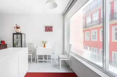 an apartment with white walls and windows and a red rug at Miguel Bombarda - Porto Houses & Suites in Porto