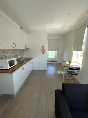 a kitchen and living room with a couch and a table at Antas Place B in Porto