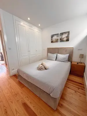 a living room with white cabinets and a wooden floor at Flores Street Apartment - Porto City Center in Porto