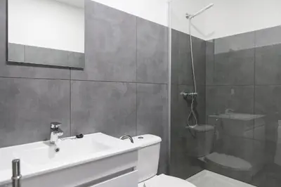 a bathroom with a toilet and a sink and a shower at Porto República Suites in Porto