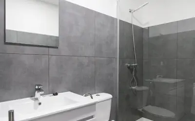 a bathroom with a white sink and a shower at Porto República Suites in Porto
