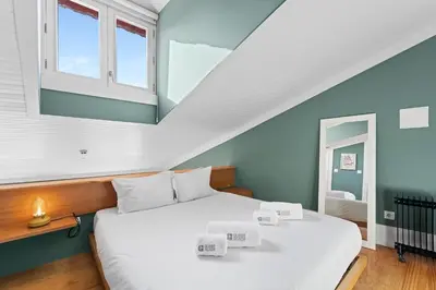 a bedroom with a large bed with white sheets at GuestReady-Cozy Duplex in Porto's Vibrant Heart in Porto