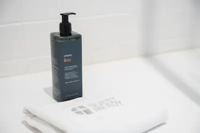a black bottle of soap sitting on top of a towel at GuestReady-Cozy Duplex in Porto's Vibrant Heart in Porto