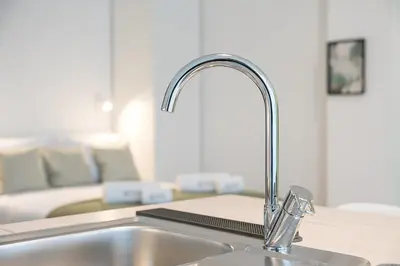 a kitchen counter with a sink in a kitchen with a couch at GuestReady - Charming Studio in Porto Centre in Porto