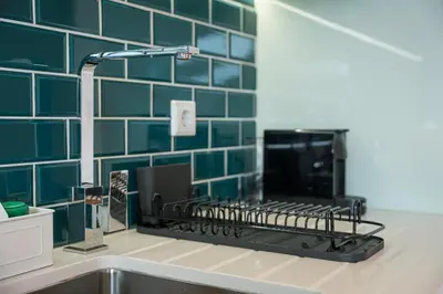 a kitchen counter with a stove with green tiles at GuestReady - Urban comfort in Boavista in Porto