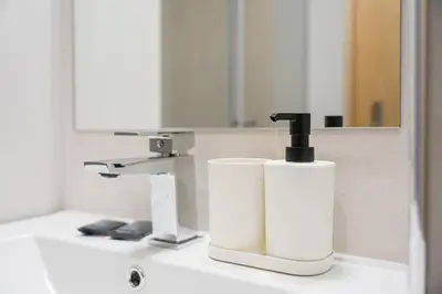 a bathroom sink with a soap dispenser and a mirror at GuestReady - Urban comfort in Boavista in Porto