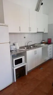 a kitchen with white cabinets and a sink and a microwave at Historical Porto Apartment in Porto