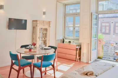 a dining room with a table and chairs and a window at Studio Palazzo, Antique Charm with Romantic Balcony and AC in Porto