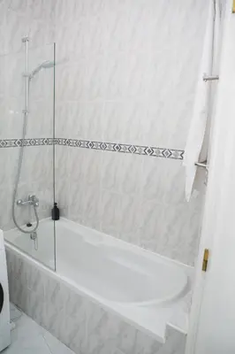 a white bath tub in a bathroom with a shower at Apartment 1 min walk from Metro and Trendiest Neighborhood Bonfim in Porto