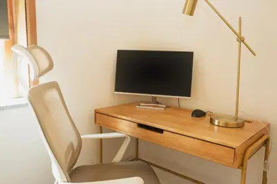 a desk with a computer monitor and a chair at Apartment 1 min walk from Metro and Trendiest Neighborhood Bonfim in Porto