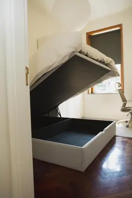a bed in the corner of a room at Apartment 1 min walk from Metro and Trendiest Neighborhood Bonfim in Porto
