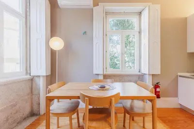 a dining room with a wooden table and chairs at Cozee Camões in Porto