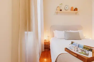 a bedroom with a white bed and a window at Cozee Camões in Porto