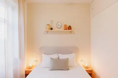 a bedroom with a white bed with white pillows at Cozee Camões in Porto