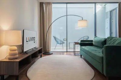 a living room with a green couch and a large window at Liiiving in Porto - The Prestige Apartment C in Porto