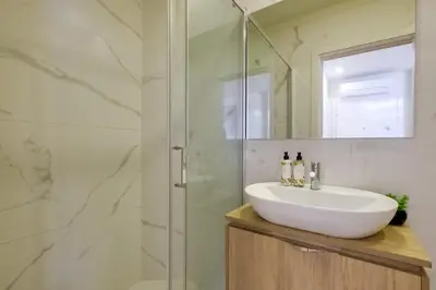 a bathroom with a sink and a glass shower at Magnolia 3 Luxury with AC Metro Downtown Porto in Porto