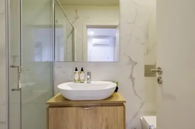 a bathroom with a white sink and a shower at Magnolia 3 Luxury with AC Metro Downtown Porto in Porto